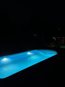 a swimming pool in the dark with blue lighting at Domki W Sercu Mazur Dla Młodzieży i Dorosłych in Ryn