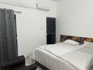 a bedroom with a large bed and a chair at The Seven Suites - Fort View in Chittaurgarh +11 photos