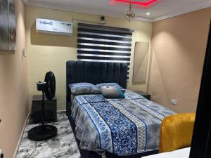 a bedroom with a bed with a blue comforter at Excel & BE Great Apartment in Lagos