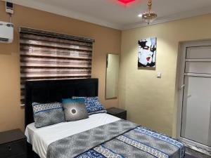 a bedroom with a bed with pillows and a window at Excel & BE Great Apartment in Lagos