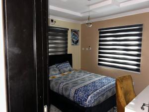 a bedroom with a bed and a window at Excel & BE Great Apartment in Lagos