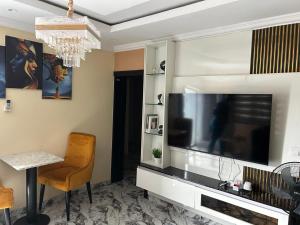 a living room with a large flat screen tv at Excel & BE Great Apartment in Lagos