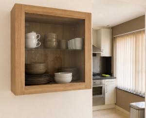 a kitchen with a cabinet with plates and cups at apartment 2 miles from Maastricht in Lanaken