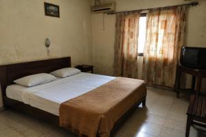 a bedroom with a bed and a television at NH hôtel in Antananarivo