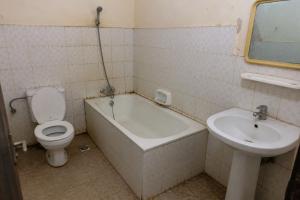 a bathroom with a toilet and a tub and a sink at NH hôtel in Antananarivo