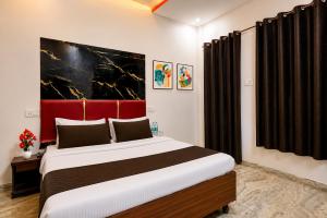 a bedroom with a large bed with a red headboard at Hotel Red Hut Chandigarh railway station in Zirakpur +10 photos