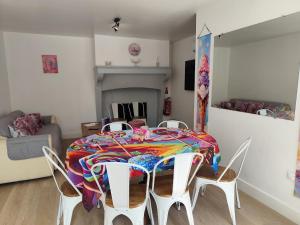 a dining room with a table and chairs with a colorful blanket at Candyland in Argançon +14 photos