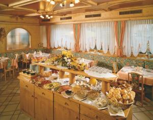 een buffet met gerechten in een restaurant met tafels bij Pension Felseneck in San Leonardo in Passiria