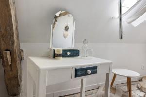 a white vanity with a mirror on top of it at Logis des gourmets in Hommes +60 photos