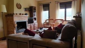 a living room with a couch and a fireplace at Casa de dos habitaciones con piscina en Cabañeros in Navas de Estena