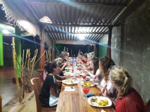 a group of children sitting at a long table eating food at All View Safari Cottage in Timbulketiya