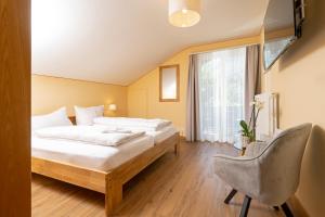 ein Hotelzimmer mit einem Bett und einem Stuhl in der Unterkunft Hotel Galina Self-Check-in in Malbun