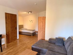 a living room with a couch and a bed at Hotel Heimfeld Restaurant Cafe in Garching an der Alz