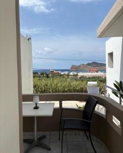 a balcony with a table and chairs and a view of the ocean at Suva Apartments Chania in Agia Marina Nea Kydonias