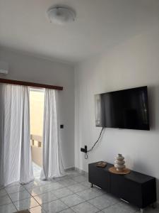 a living room with a flat screen tv on the wall at Suva Apartments Chania in Agia Marina Nea Kydonias