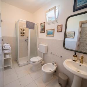 a bathroom with a toilet and a sink and a shower at Pupi Catania Etna Farm in Catania