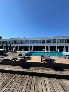 a building with a swimming pool and benches on a deck at Вілла с басейном in Zatoka