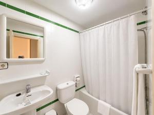 a bathroom with a white toilet and a sink at Hostal ** EC León in León