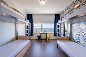 a room with two bunk beds and a table with a view at Stayokay Hostel Terschelling in West-Terschelling +54 photos