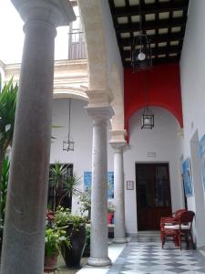 a lobby with columns and a red and white building at Casa del Regidor in El Puerto de Santa María