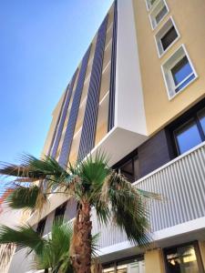 a palm tree in front of a building at Nemea Appart Hotel Sunset Nice Arenas in Nice
