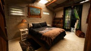 a small bedroom with a bed and a table at 11 Mountain Stream Hot Tub Self Catering in Gordonʼs Bay +124 photos