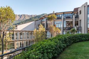 an apartment building with mountains in the background at Copthorne Hotel & Resort Lakefront Queenstown in Queenstown