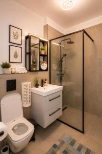ein Badezimmer mit Toilette, Dusche und Waschbecken in der Unterkunft Wise Nest Studio with pool and spa in Sinaia