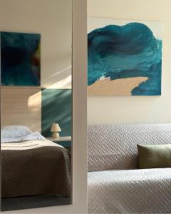 a bedroom with a bed and a painting on the wall at Palangos Dailė in Palanga