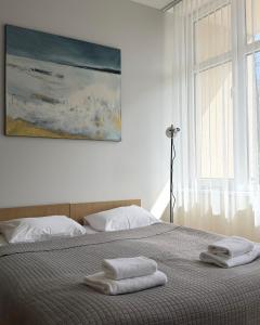 a bedroom with a bed with two towels on it at Palangos Dailė in Palanga +17 photos