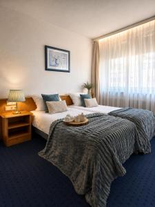 a hotel room with two beds and a table at Hotel Kreuzplatz Gießen Zentrum in Gießen