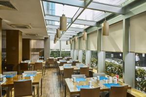 a restaurant with tables and chairs and windows at Avantgarde Urban Levent in Istanbul