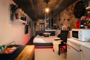 a bedroom with a bed and a kitchen with a microwave at Sweet Loft Grenoble-Love Room avec jacuzzi & sauna in Grenoble