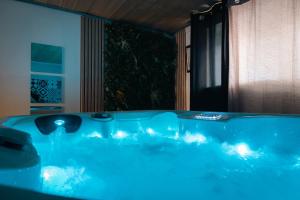 a blue bath tub with lights in a room at Sweet Loft Grenoble-Love Room avec jacuzzi & sauna in Grenoble