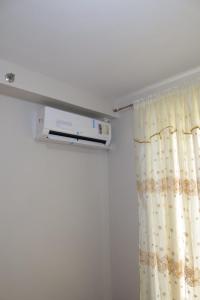 a room with a curtain and a air conditioner at Amori Spaces - MGD in Suba