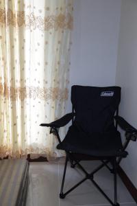 a black chair sitting in front of a curtain at Amori Spaces - MGD in Suba +3 photos