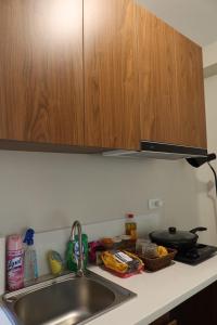 a kitchen counter with a sink and wooden cabinets at Amori Spaces - MGD in Suba