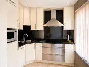 a kitchen with white cabinets and a stainless steel sink at apartment 2 miles from Maastricht in Lanaken