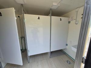 a white bathroom with a shower and a toilet at Willage camp i auto camp KOMARNICA in Šavnik