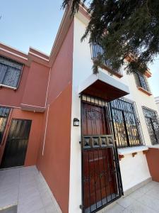 a red and white house with a red door at Departamento en Manta amoblado con seguridad privada in Manta