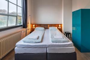 a bedroom with two beds and a blue cabinet at Stayokay Hostel Eindhoven in Eindhoven +29 photos