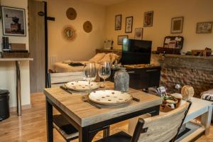 a table with two plates and wine glasses on it at gîte Cosy Green 2 in Chevincourt