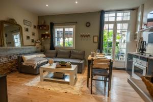 a living room with a couch and a table at gîte Cosy Green 2 in Chevincourt