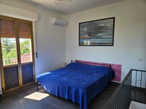a bedroom with a bed with a blue comforter at Villa Costa Viola in San Roberto