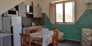 a kitchen with a table and chairs and a refrigerator at Villa Costa Viola in San Roberto