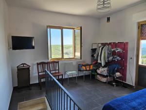 a room with a bed and chairs and a television at Villa Costa Viola in San Roberto