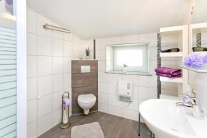 a white bathroom with a toilet and a sink at Ferienwohnung Meeresbrise in Groß Kordshagen +22 photos