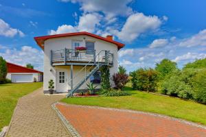 a house with a balcony on a brick driveway at Ferienwohnung Meeresbrise in Groß Kordshagen