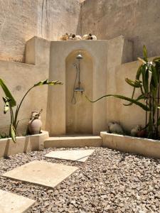 a shower in a wall with some plants and rocks at Dar Younes in Houmt Souk