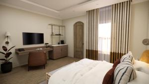 a bedroom with a bed and a desk and a television at Eendracht Hotel in Stellenbosch